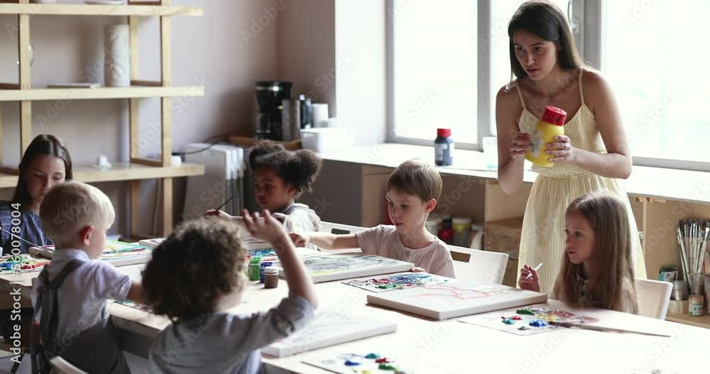 Multiethnic children, group of little cute boys and girls sit at table ...