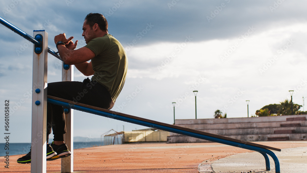 Strong athletic guy doing abs exercises outdoor Strong athletic guy doing abs exercises outdoor