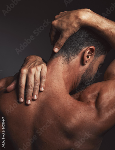 Stretching, fit man and back muscle on dark black studio background. Self love, self care and model embracing skin, confidence and body positivity with an artistic body hug and creative expression