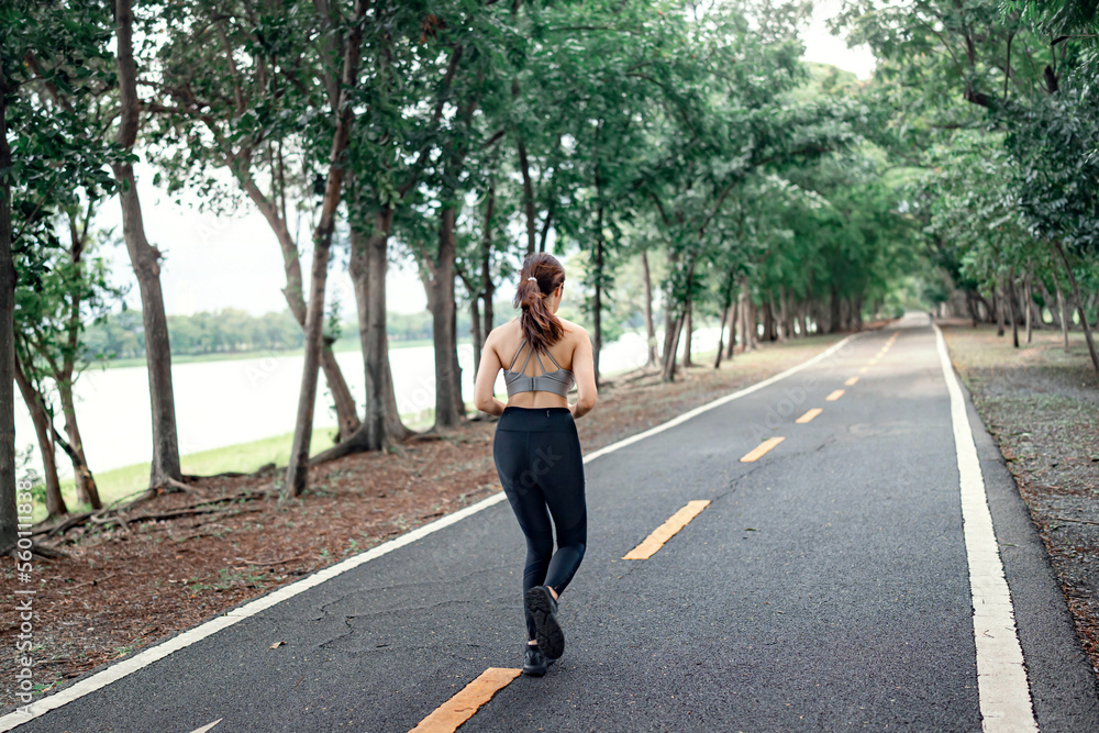 Healthy woman runner running in the park in the morning. Healthy lifestyle concept Healthy woman runner running in the park in the morning. Healthy lifestyle concept