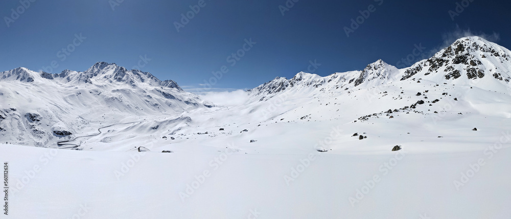 Ski mountaineering in a beautiful snowy mountain field. Tour above the Fluelapass in Switzerland. Panorama picture