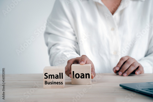 Small business loan, The concept of starting a new business for the new generation applying for credit Small businessman hand touching wooden cube offering approve investment money
