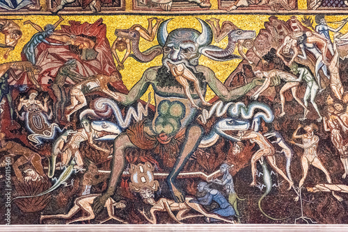 Close-up on religious mosaic decorating catholic church in Florence showing a demon eating people in hell