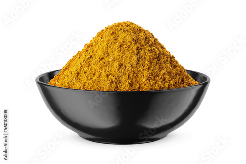 Curry powder in round black bowl isolated on white. Front view.