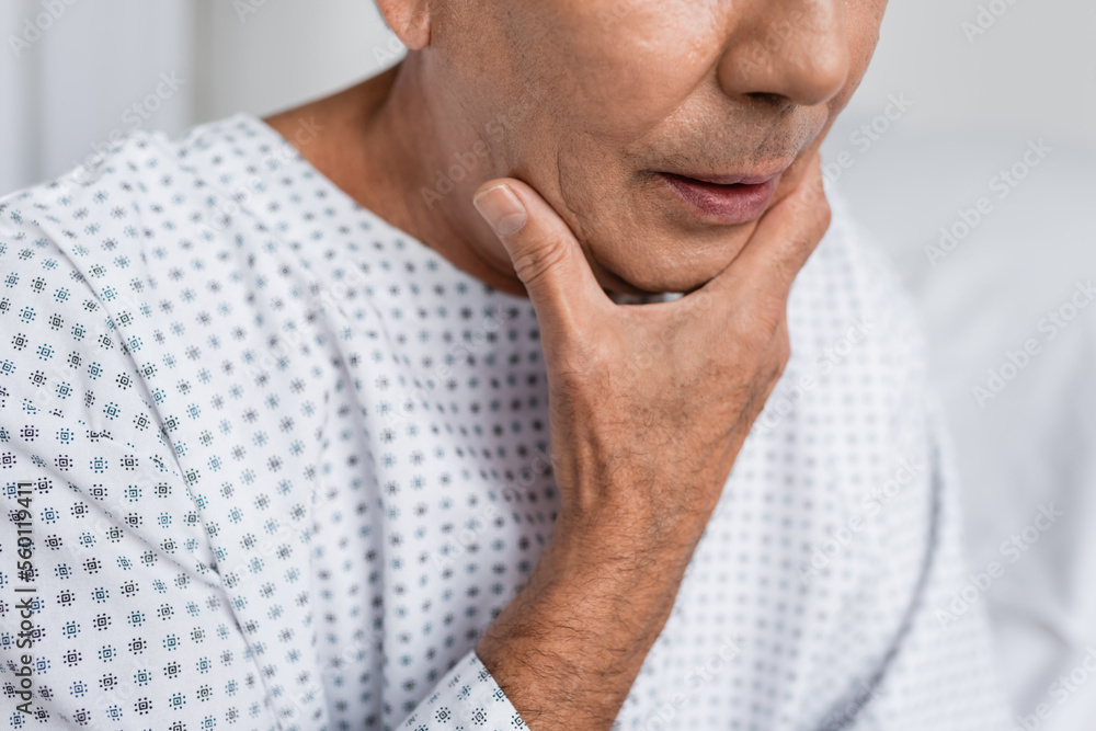 Cropped view of elderly patient touching chin in hospital ward. Cropped view of elderly patient touching chin in hospital ward.