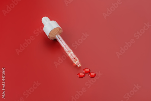 Dropper glass bottle cap mockup. Cosmetic pipette. red background. Concept of anti age and beauty cosmetics. minimalism, skin care © IKvyatkovskaya