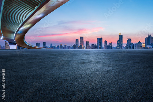 Asphalt road and city skyline with modern buildings in Shanghai at sunset, China.