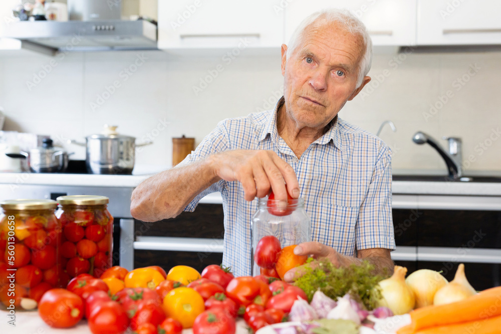 old man holding jars of pickled tomatoes and smiling old man holding jars of pickled tomatoes and smiling