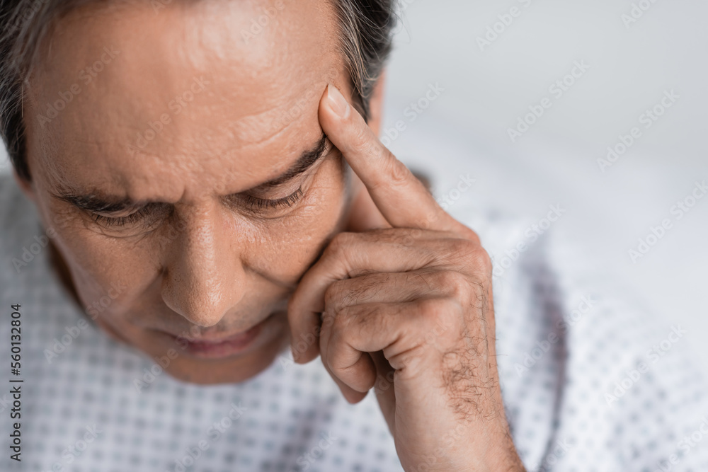 Ill senior patient in gown sitting in clinic. Ill senior patient in gown sitting in clinic.