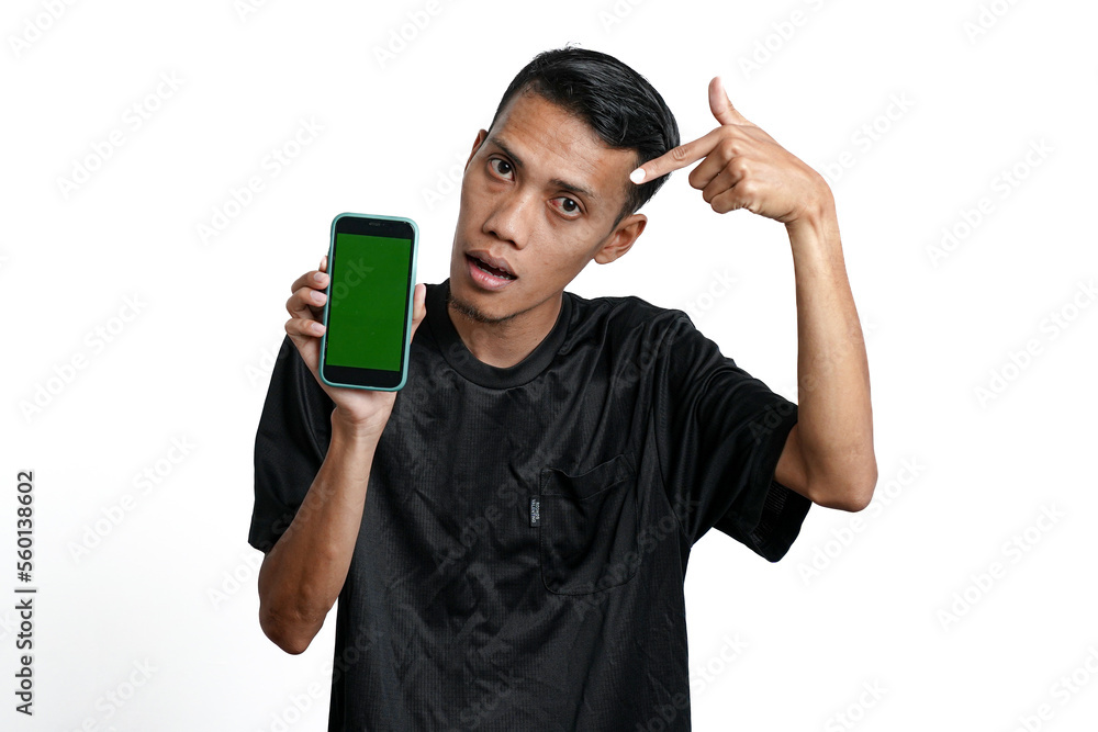 excited asian man wearing black workout t-shirt, pointing at green screen of smartphone. Isolated by white background excited asian man wearing black workout t-shirt, pointing at green screen of smartphone. Isolated by white background