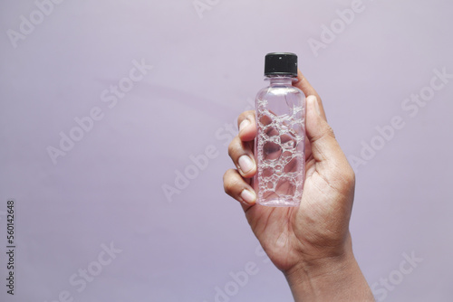  hand hold a mouthwash liquid container 