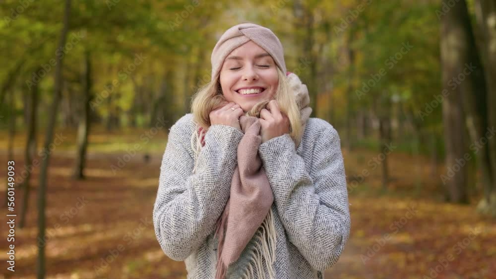 Front view of attractive, blonde woman wearing stylish clothes, walking in park. Beautiful, young lady standing, smiling, enjoying nice weather. Concept of autumn and coziness. Front view of attractive, blonde woman wearing stylish clothes, walking in park. Beautiful, young lady standing, smiling, enjoying nice weather. Concept of autumn and coziness.