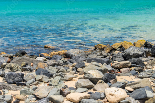 Rocky beach and a calm turquoise sea on a beach in Sint Marteen