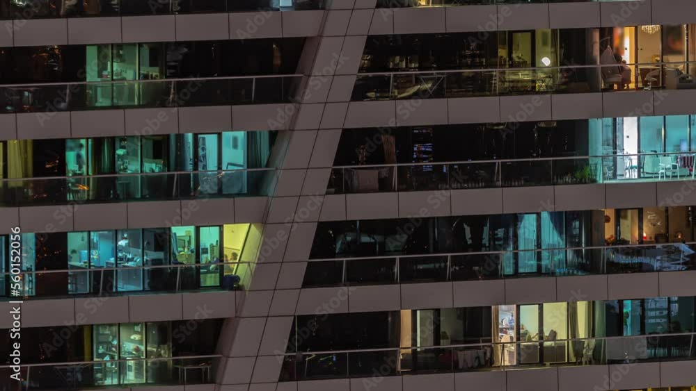 Night view of many glowing windows in apartment residential tower timelapse. High rise skyscraper with lights and motion in rooms Night view of many glowing windows in apartment residential tower timelapse. High rise skyscraper with lights and motion in rooms