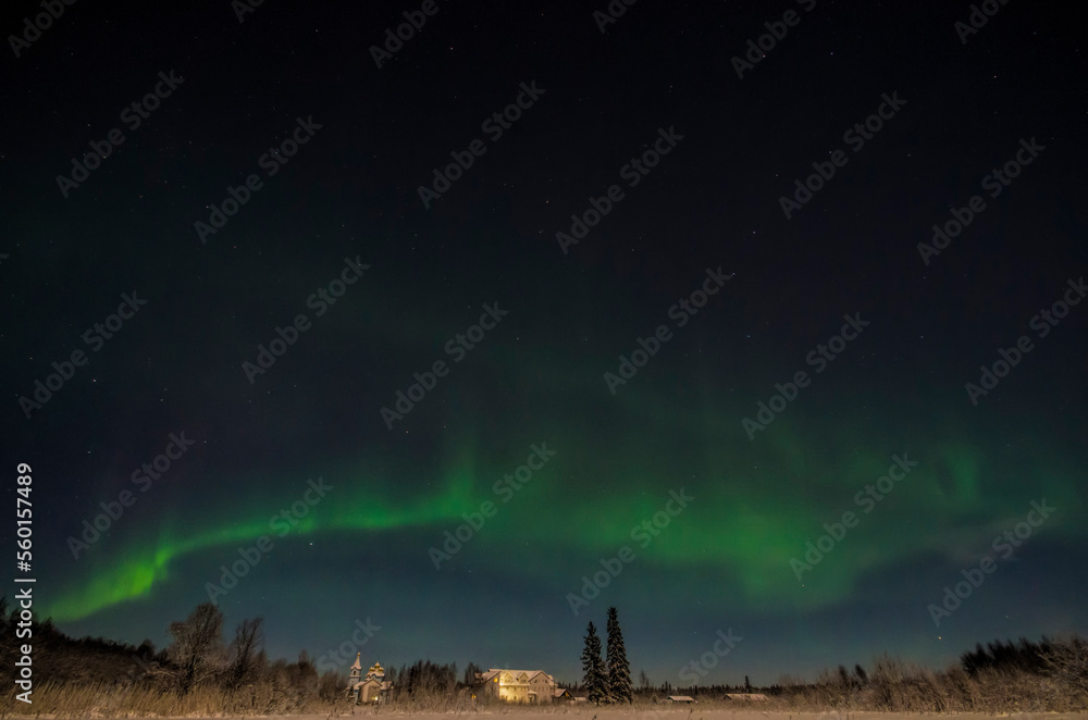 Aurora borealis over forest and temple
