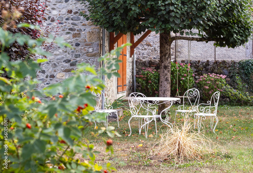 Set of white wrought metal furniture in the intimate garden in french village. 