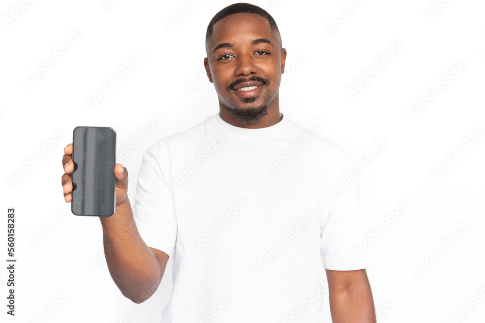 Joyful young man presenting smartphone. Male African American model with brown eyes, short haircut and beard in white T-shirt showing smartphone screen. Advertising, modern technology concept Joyful young man presenting smartphone. Male African American model with brown eyes, short haircut and beard in white T-shirt showing smartphone screen. Advertising, modern technology concept