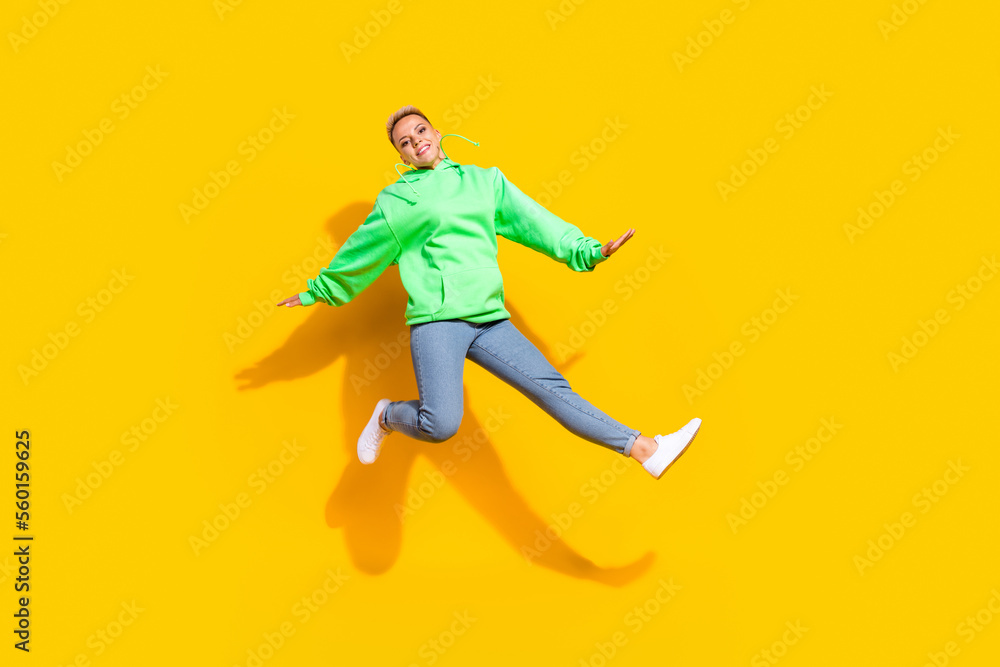 Full body photo of carefree pretty lady jumping good mood free time isolated on yellow color background