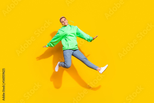 Full body photo of carefree pretty lady jumping good mood free time isolated on yellow color background