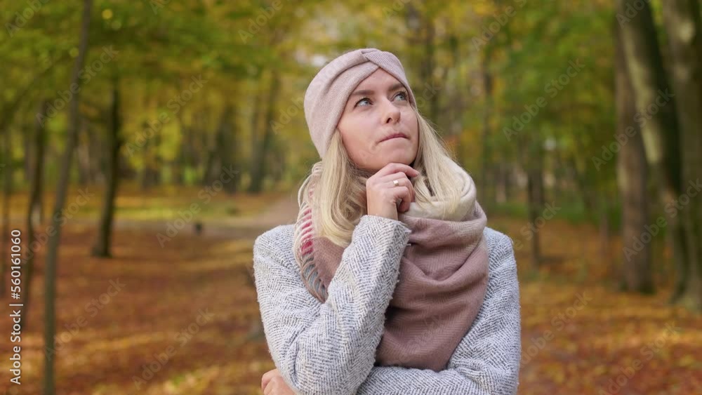 Front view of attractive, blonde woman wearing stylish clothes, standing in park. Beautiful, young lady admiring, thinking, looking up, smiling. Concept of autumn and fall. Front view of attractive, blonde woman wearing stylish clothes, standing in park. Beautiful, young lady admiring, thinking, looking up, smiling. Concept of autumn and fall.