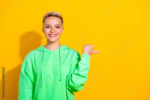Photo of optimistic satisfied lady cheerful promo recommend finger point empty space new advertisement product isolated on yellow color background