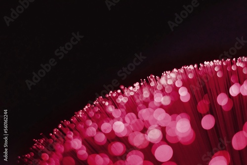 Abstract neon light in trendy color Viva Magenta on the black background. Color of the year 2023.