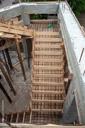 Built formwork template with metal reinforcement for pouring concrete solution of staircases  between floors of the house  immediately at the site of construction of the house
