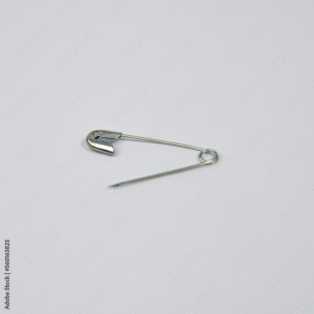 Safety pin (bahasa: Peniti) with white metal material on a white background. Safety pin (bahasa: Peniti) with white metal material on a white background.