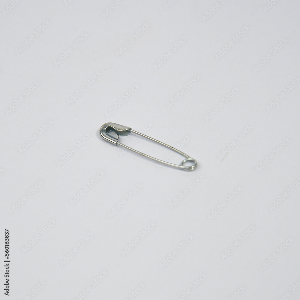 Safety pin (bahasa: Peniti) with white metal material on a white background. Safety pin (bahasa: Peniti) with white metal material on a white background.