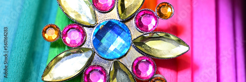 Fancy jewel brooch on colored paper, multicolored banner