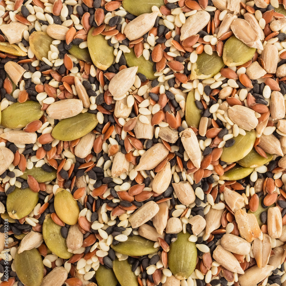 Mix of sesame seeds, sunflower seed, pumpkin. The seeds are used to produce butter, or to sprinkle flour products and as a condiment. Background, texture. top view Mix of sesame seeds, sunflower seed, pumpkin. The seeds are used to produce butter, or to sprinkle flour products and as a condiment. Background, texture. top view