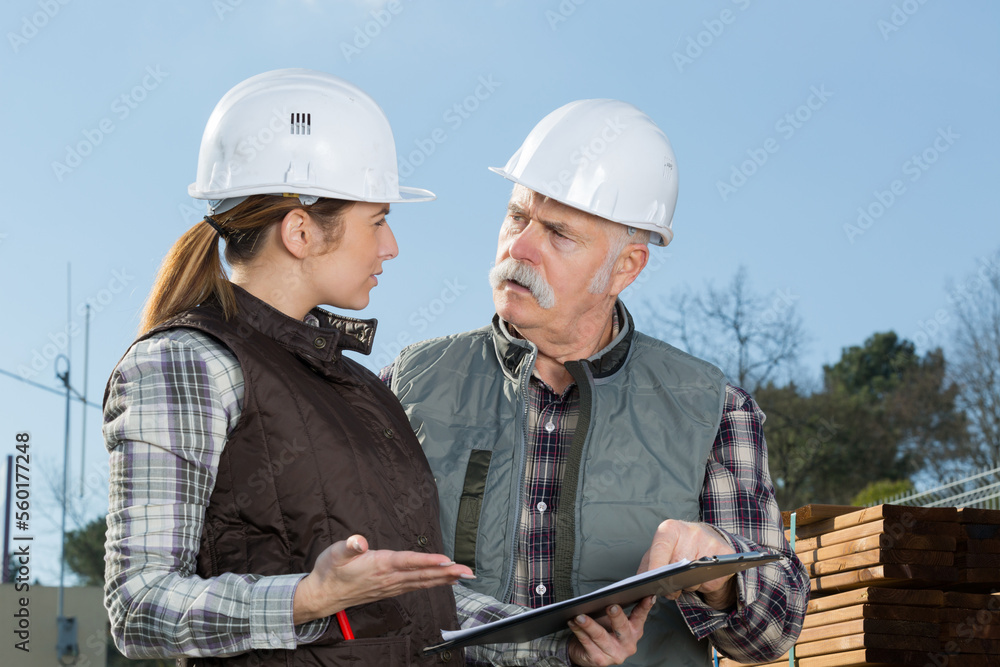 man and woman alking in hard hats man and woman alking in hard hats