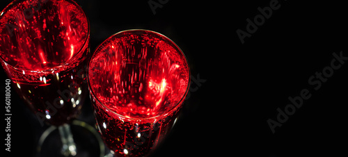 Glasses with red sparkling drink above on black background wth copy space
