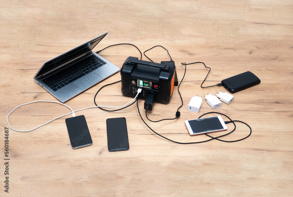 lithium Portable Power Station is charging laptop smartphones.Power banks and other gadgets..Modern, information technology. lithium Portable Power Station is charging laptop smartphones.Power banks and other gadgets..Modern, information technology.