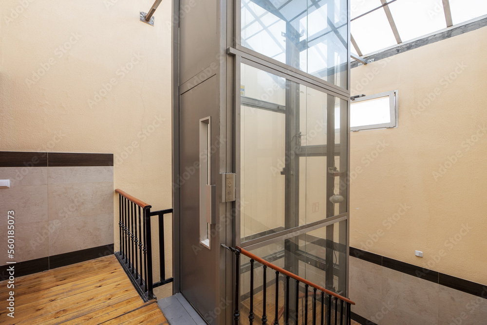 Fototapeta premium Elevator of a vintage home with skylight and pine wood stairs