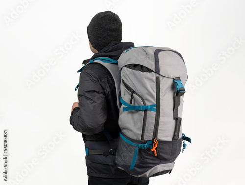 Studio photo of Brown skinned young backpacker, camper or hiker standing on isolated background. Concept of trekking or nature walking.