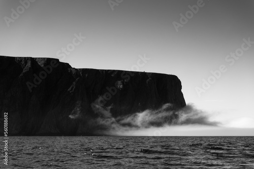 The northernmost tip of Europe large rock cliff of North Cape or Nordkapp on summer day with dramatic sea fog rising on Mageroya island in Finnmark in Northern Norway. photo