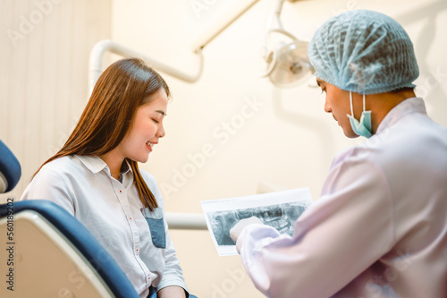The dentist is looking at the patient s dental x-ray results for an effective treatment and improves the patient s dental health and a bright smile.