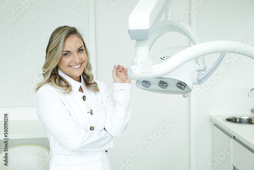 Mulher Dentista mostrando com sorriso os aparelhos utilizados.