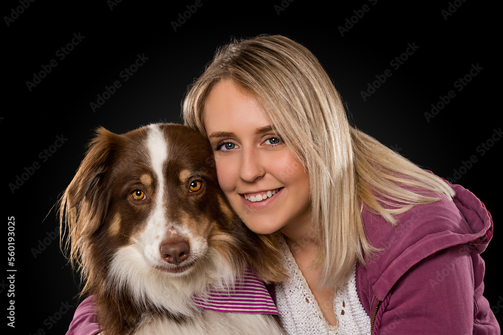 Young woman with dog on black background