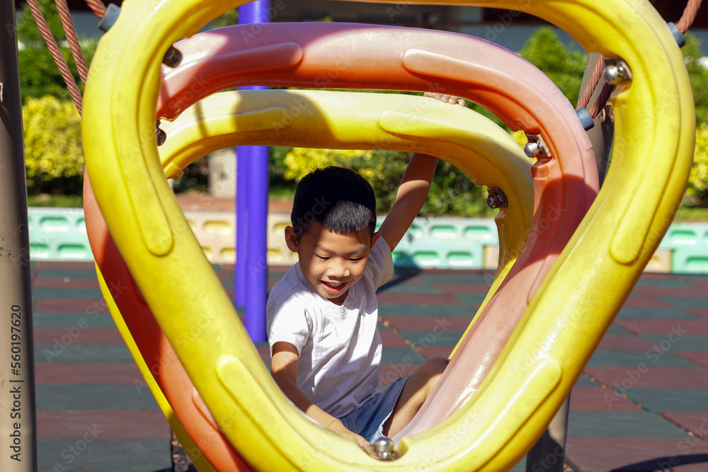 happy Asian boy and enjoy climbing on plastic hoops in the playground. Soft and selective focus. happy Asian boy and enjoy climbing on plastic hoops in the playground. Soft and selective focus.