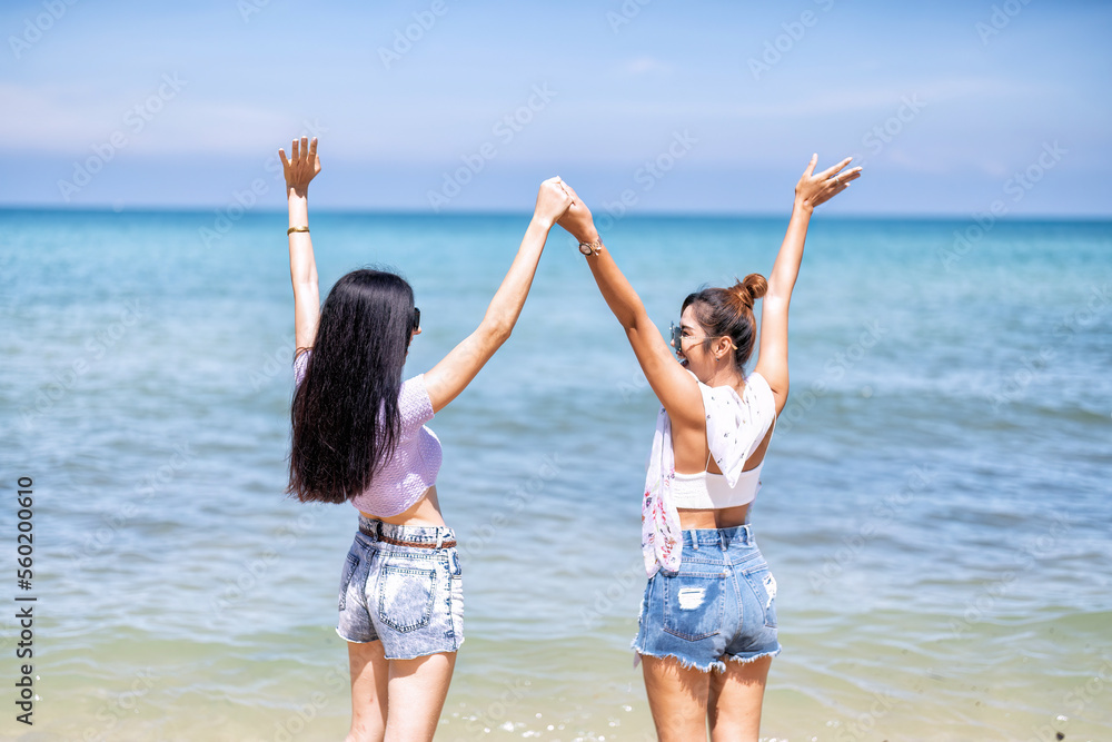 Couple LGBTQ girl on holiday happy running playing dancing along the beach on love emotion Couple LGBTQ girl on holiday happy running playing dancing along the beach on love emotion