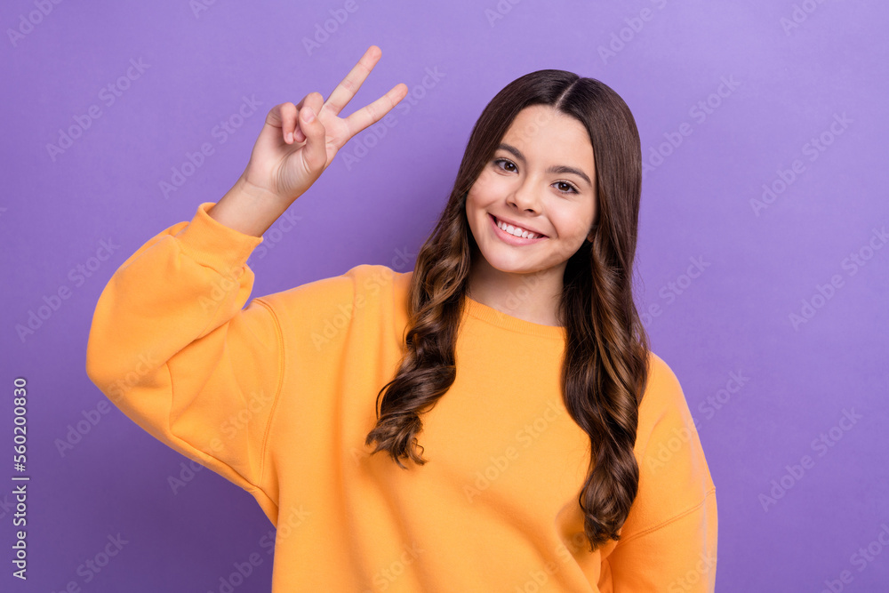 Photo of positive lovely person arm fingers demonstrate v-sign isolated on violet color background Photo of positive lovely person arm fingers demonstrate v-sign isolated on violet color background