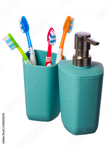 Turquoise glass with blue, red, green and orange toothbrushes complete with soap dispenser on a white background. The vertical position of the frame. Highlighted in white. 