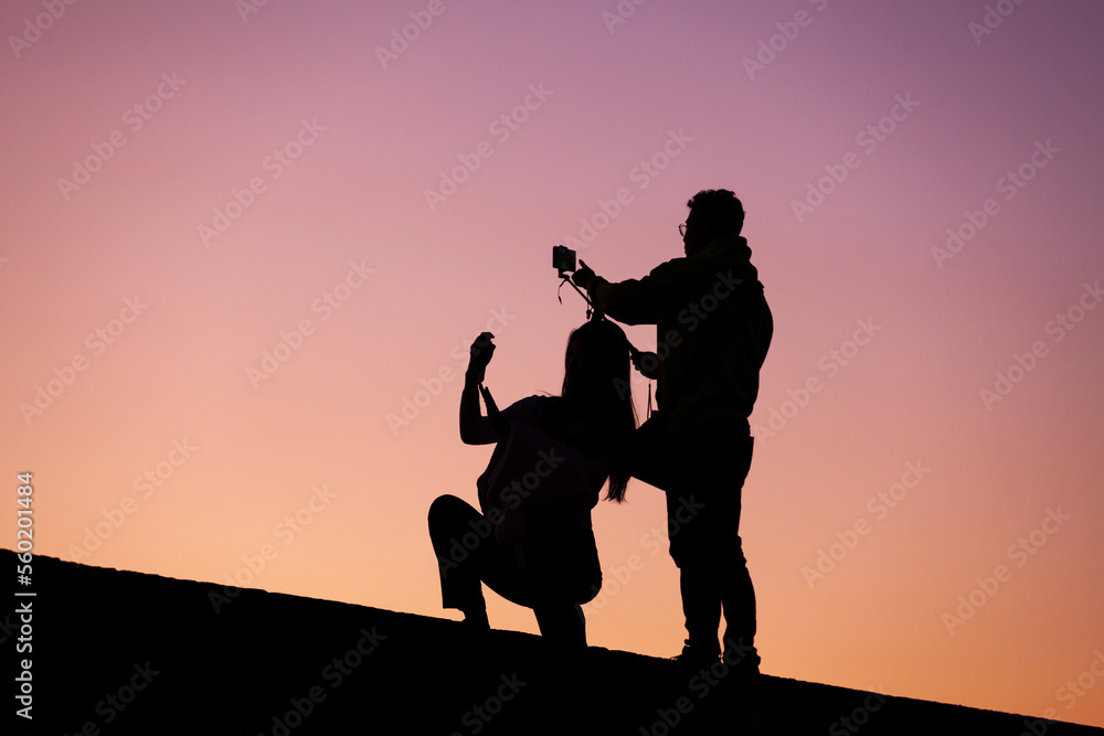 Fototapeta premium people taking pictures at sunset selfie silhouette valentine's day