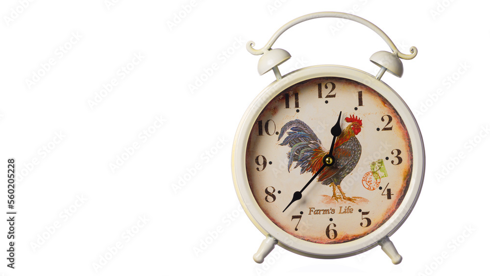 Beige alarm clock with a rooster painted on the dial on a white background. The horizontal position of the frame is 16x9. Free space for text advertising. Highlighted in white. Beige alarm clock with a rooster painted on the dial on a white background. The horizontal position of the frame is 16x9. Free space for text advertising. Highlighted in white.