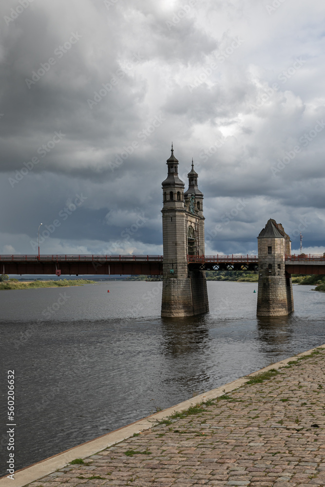 Medieval stone bridge over a river in northern Europe. This is the Queen Louise Bridge over the Neman River in the city of Sovetsk, Kaliningrad region. There is a border between Russia and Lithuania