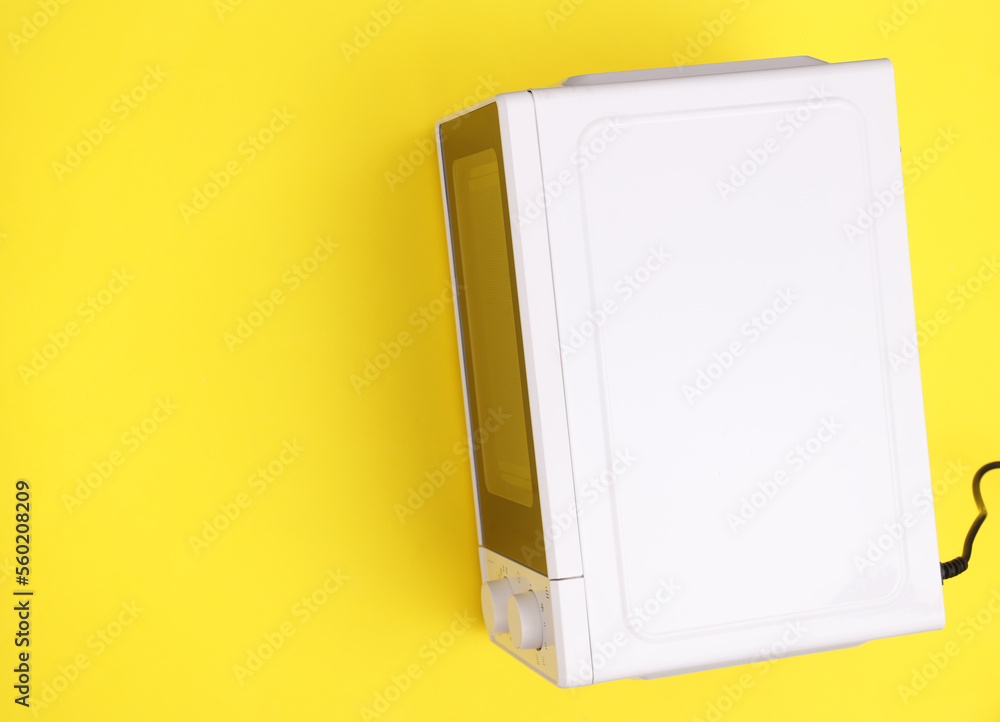 White microwave oven on a yellow background. Top view. Copy space White microwave oven on a yellow background. Top view. Copy space