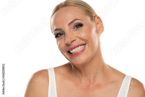 Portrait of senior middle aged happy blond woman with makeup on white background