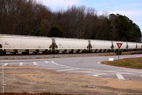 Freight cars being pulled by diesel train moving along the tracks background.